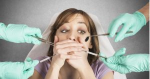 woman surrounded by dental instruments who's afraid